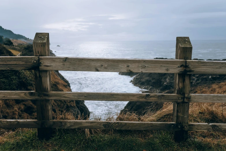 a wooden fence that is by the ocean