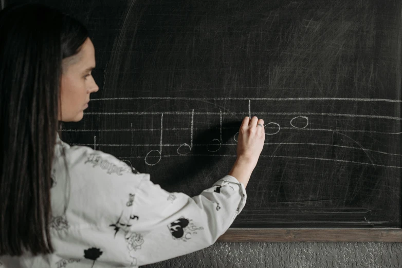 a girl is writing on a chalk board