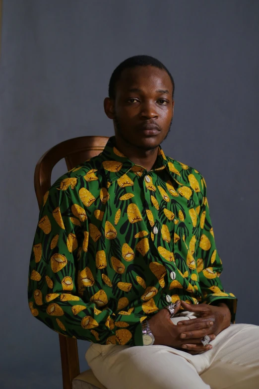 a black man with white pants and green and yellow shirt