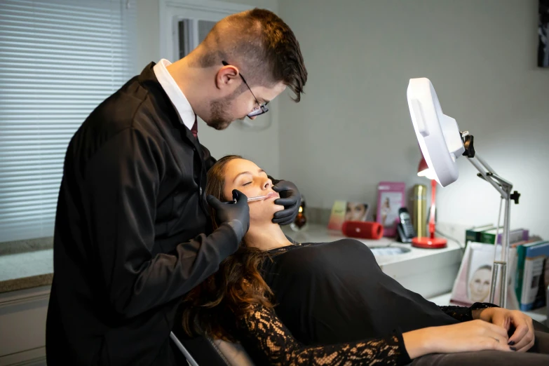 a man putting a woman's nails at her feet