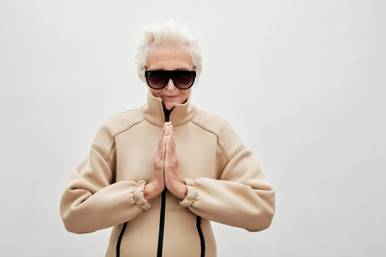 an older person in sunglasses standing and praying