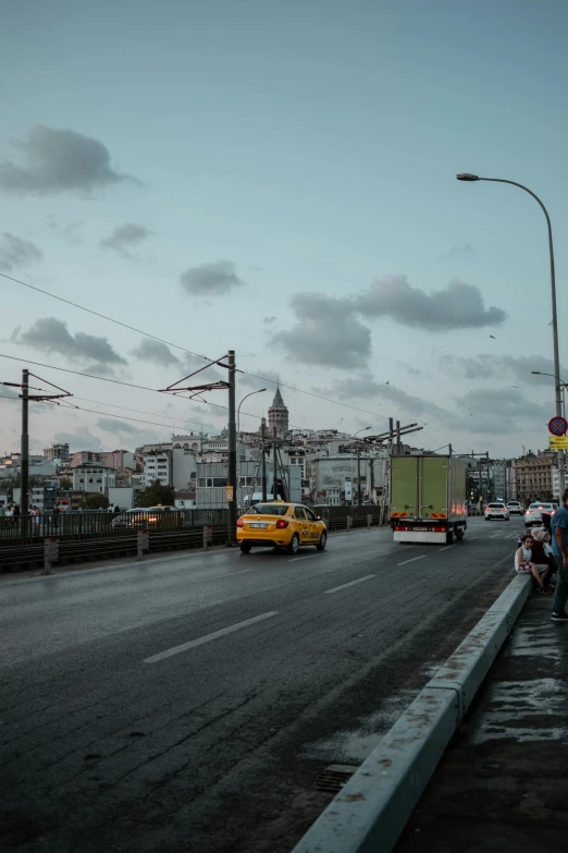 people standing next to a busy roadway in the city