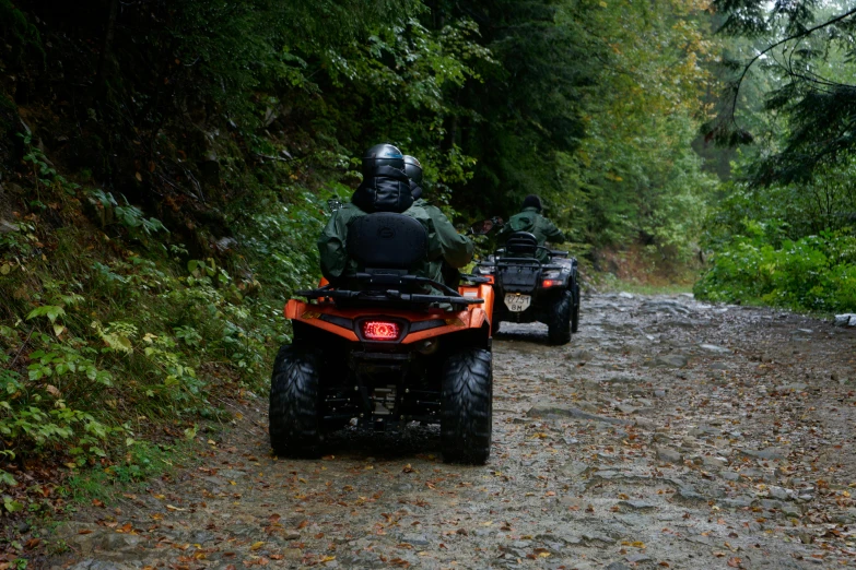 two atv riders are traveling in their sidecars on a trail