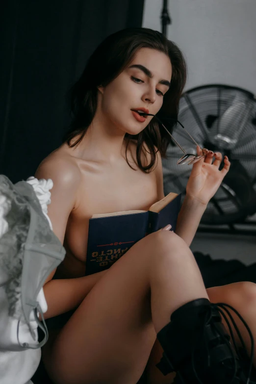 a beautiful woman reading a book with a cigarette