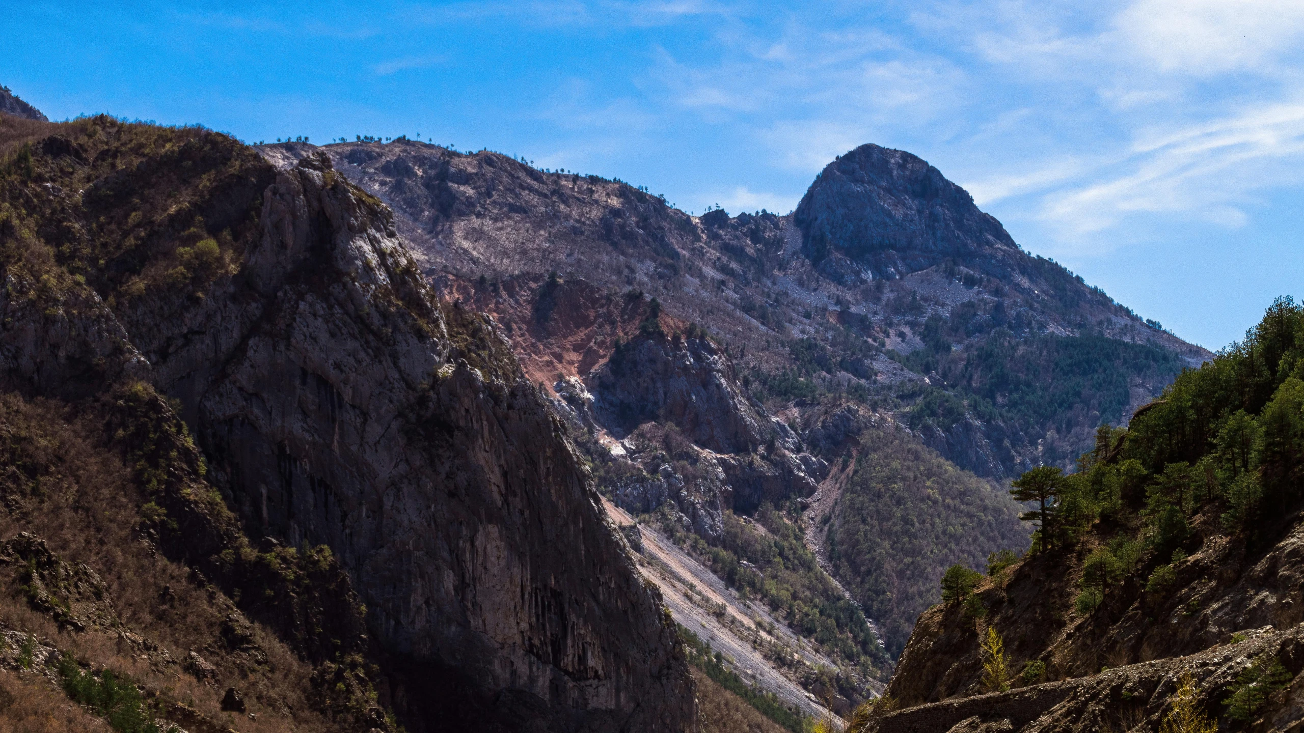 the mountains are very steep and there is a blue sky