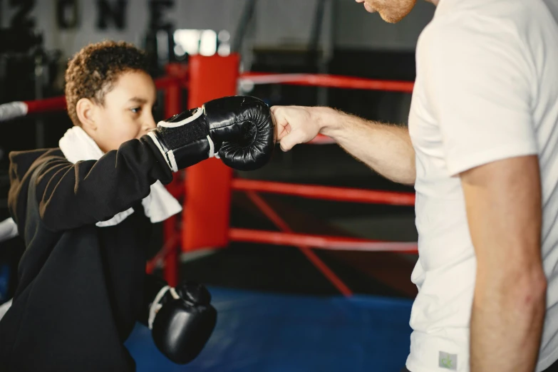 a child at a boxing training with trainer