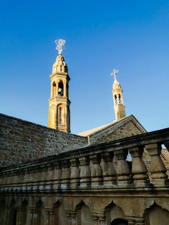 an old building with a tower and two crosses on top