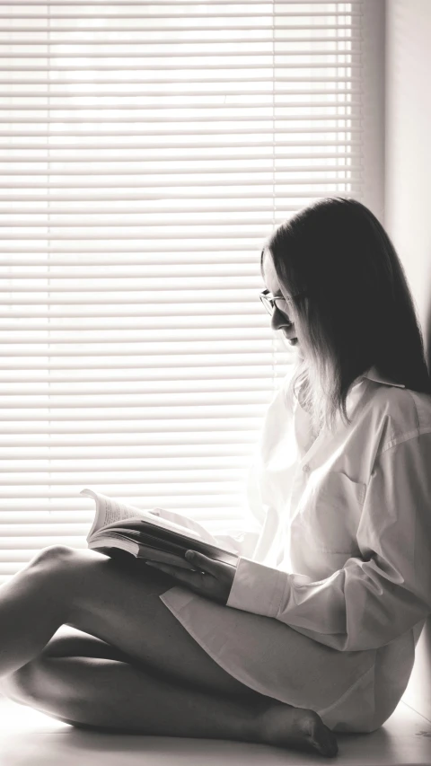 woman sitting on the floor reading a book