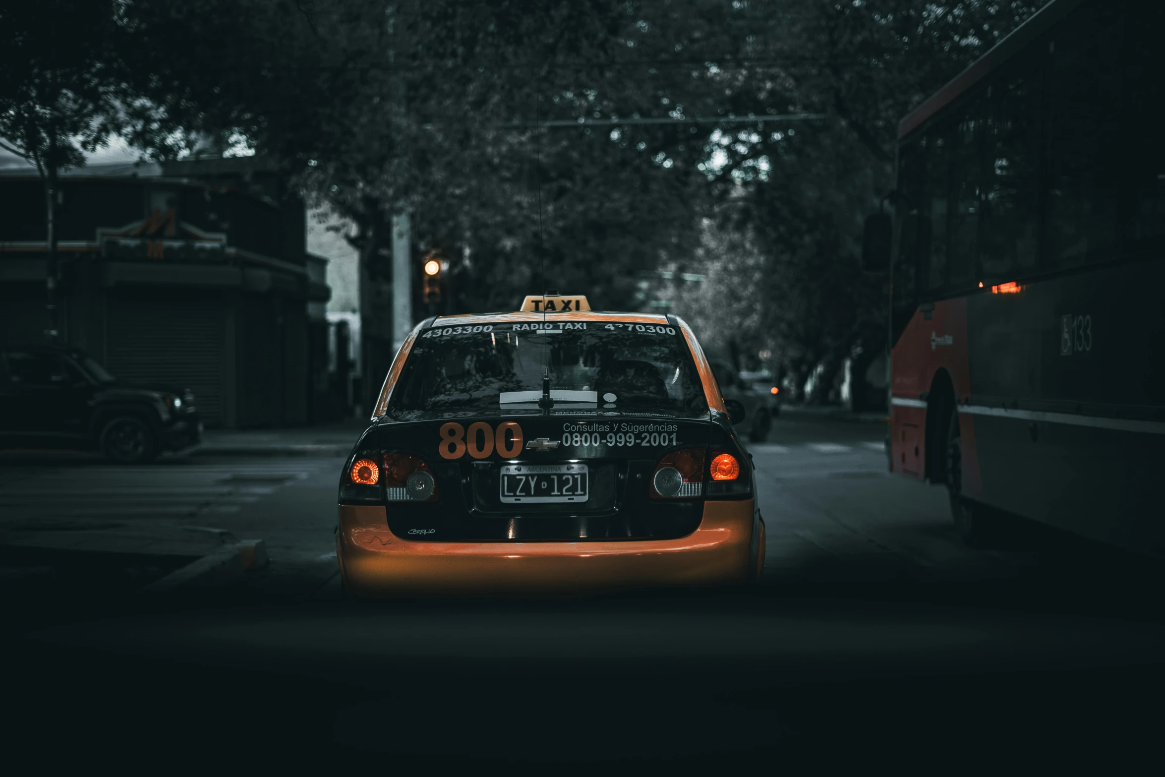 a black taxi cab driving down a street