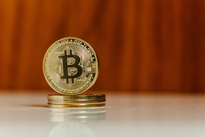 a closeup of a gold bit coin on a white table