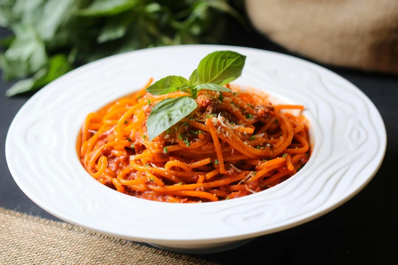 the plate is full of the spaghetti with fresh basil on top