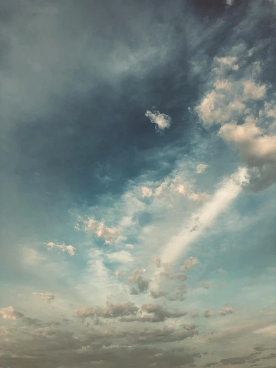 several white clouds in a sky over a field