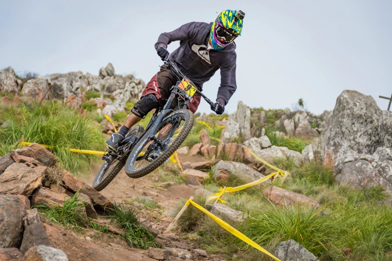 a man rides on a bike in the grass and rocks