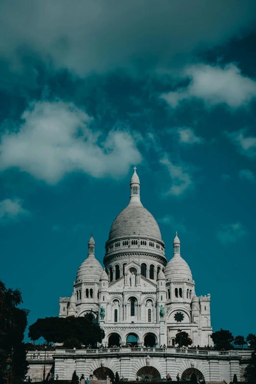 a very big building under some clouds in the sky