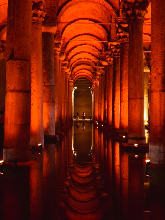 long rows of carved and lit pillars line this corridor in a city