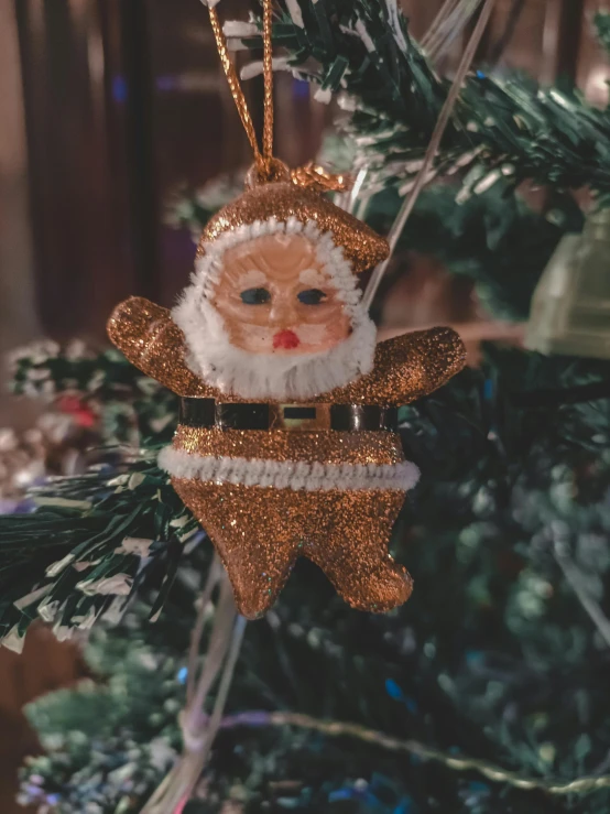 a christmas ornament in the shape of santa claus on a christmas tree