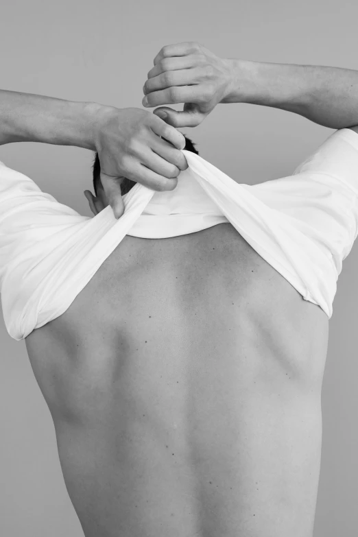 a man showing his back with an open white shirt