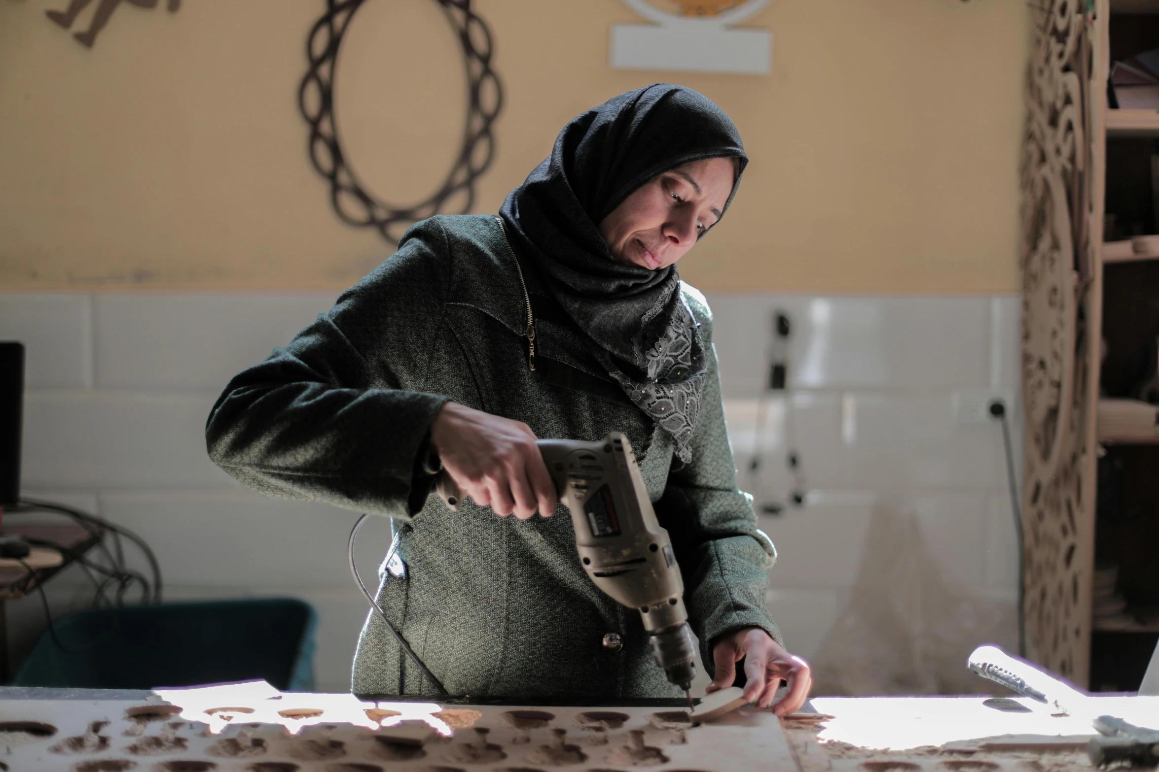 a woman wearing a head covering using a cordless device