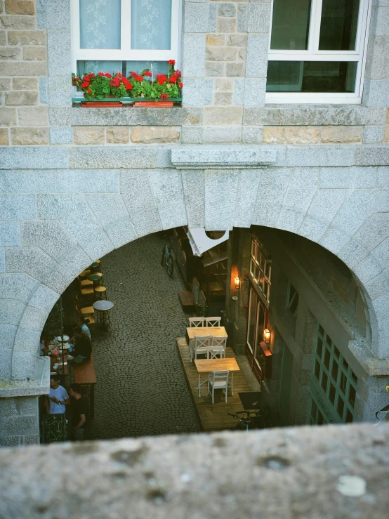 two people sitting at tables in an arched entrance