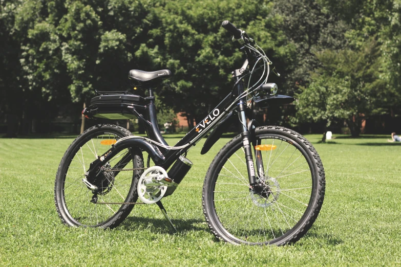 a bike in a grassy field with trees in the background