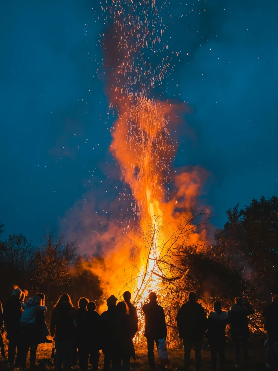 a large crowd watching some people around the fire