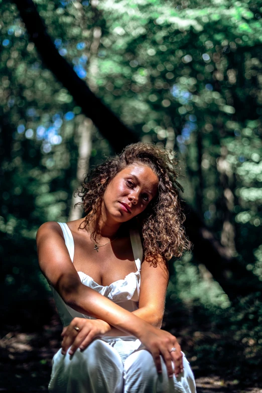 a young woman poses in the woods for a portrait