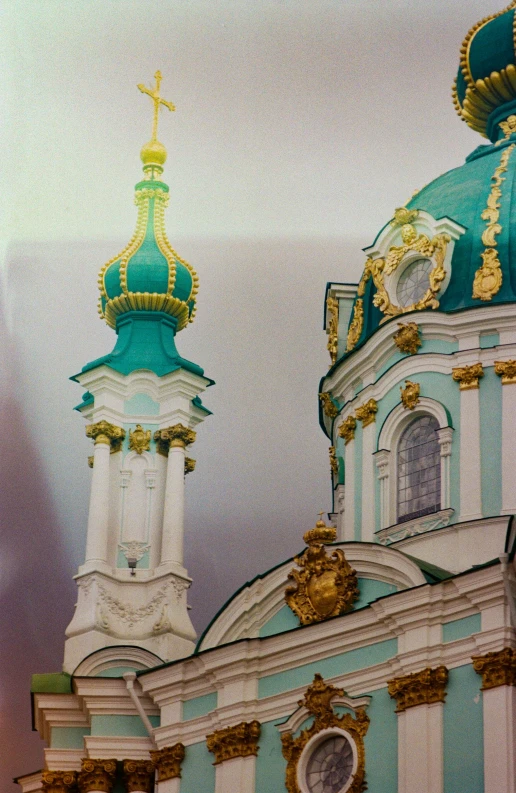 the top of an ornate building with a golden clock