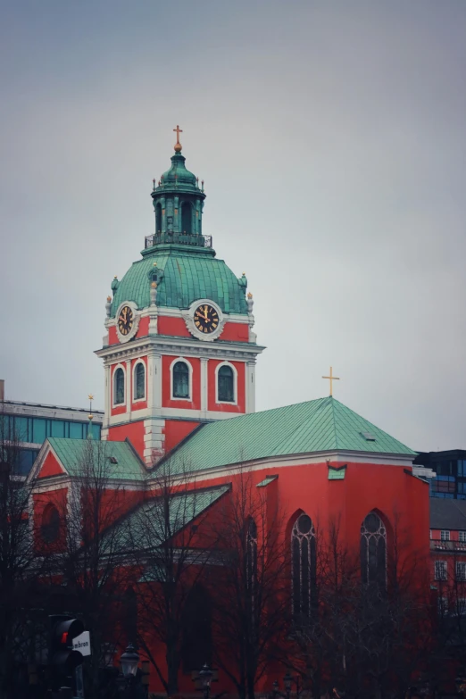 the large red building has a clock tower on top