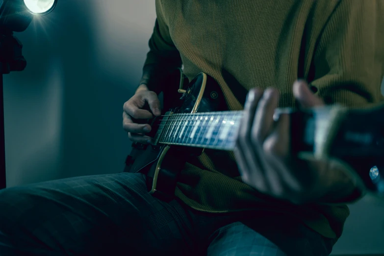 a person is playing the guitar in the room