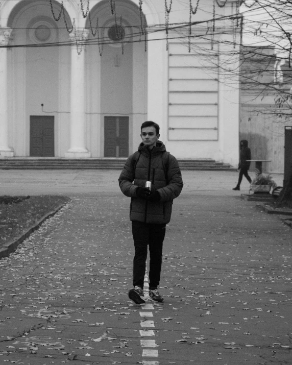 a man standing alone in front of a building