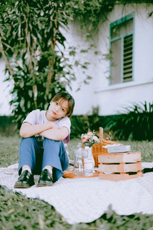 a girl on the ground with her arms folded next to boxes