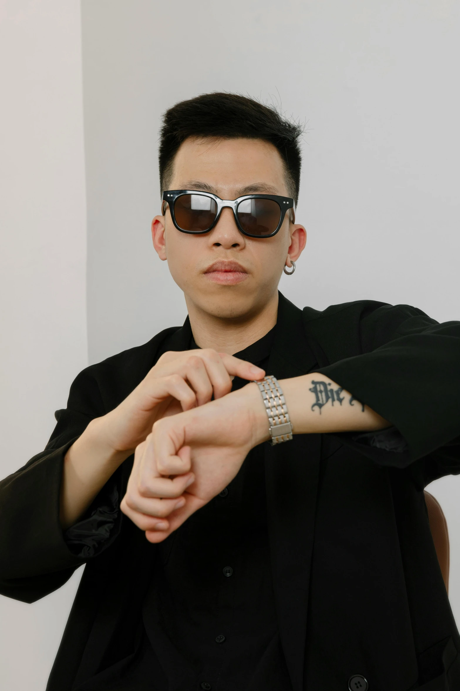 an asian male wearing sunglasses and a black shirt