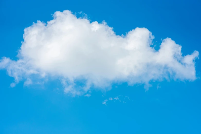 a big cloud shaped in the sky with birds flying above it