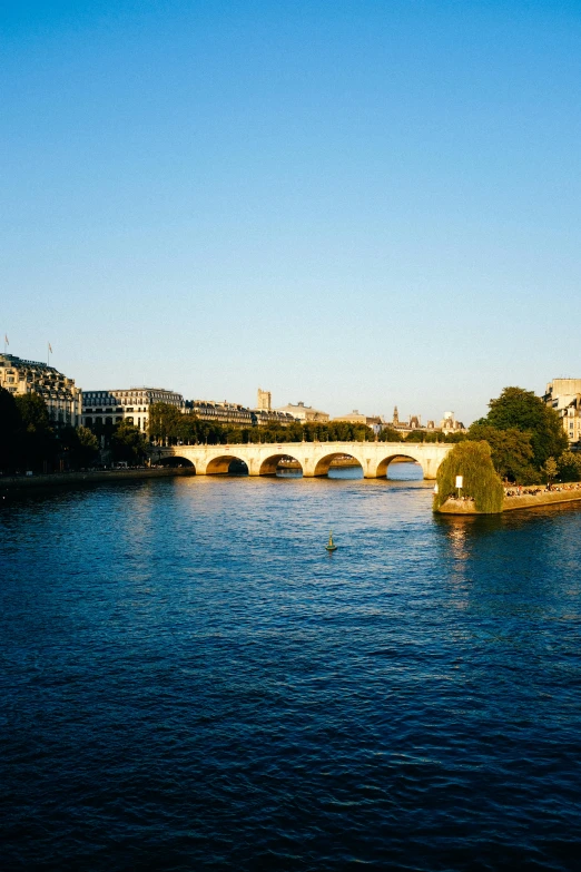 a river with a bridge in the background