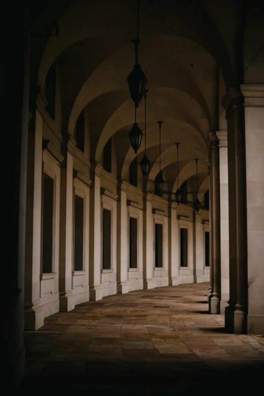 an empty hall is shown with lantern lights and pillars