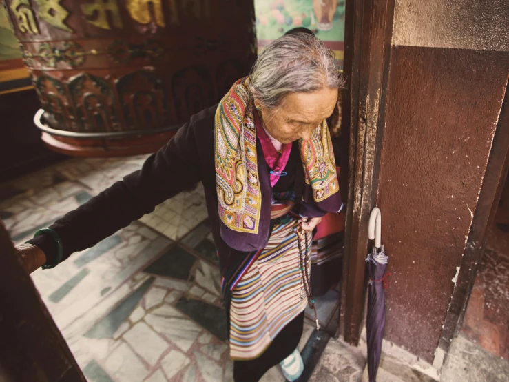 an elderly woman stands in the doorway to get inside