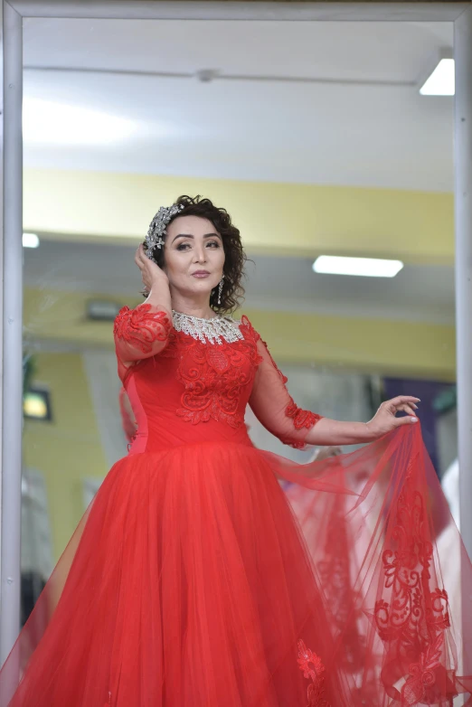 a woman poses in a red dress while posing