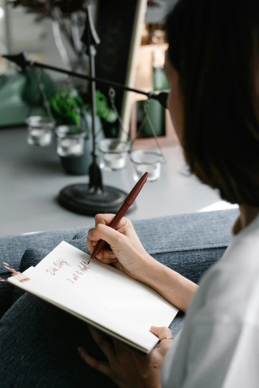 a woman is sitting down and writing on her paper