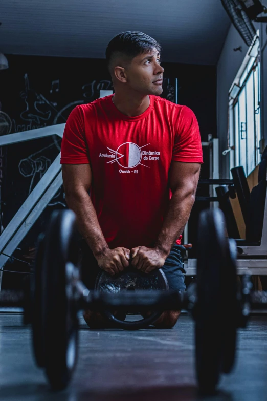 a man squats in the cross - training gym while holding dumbbells