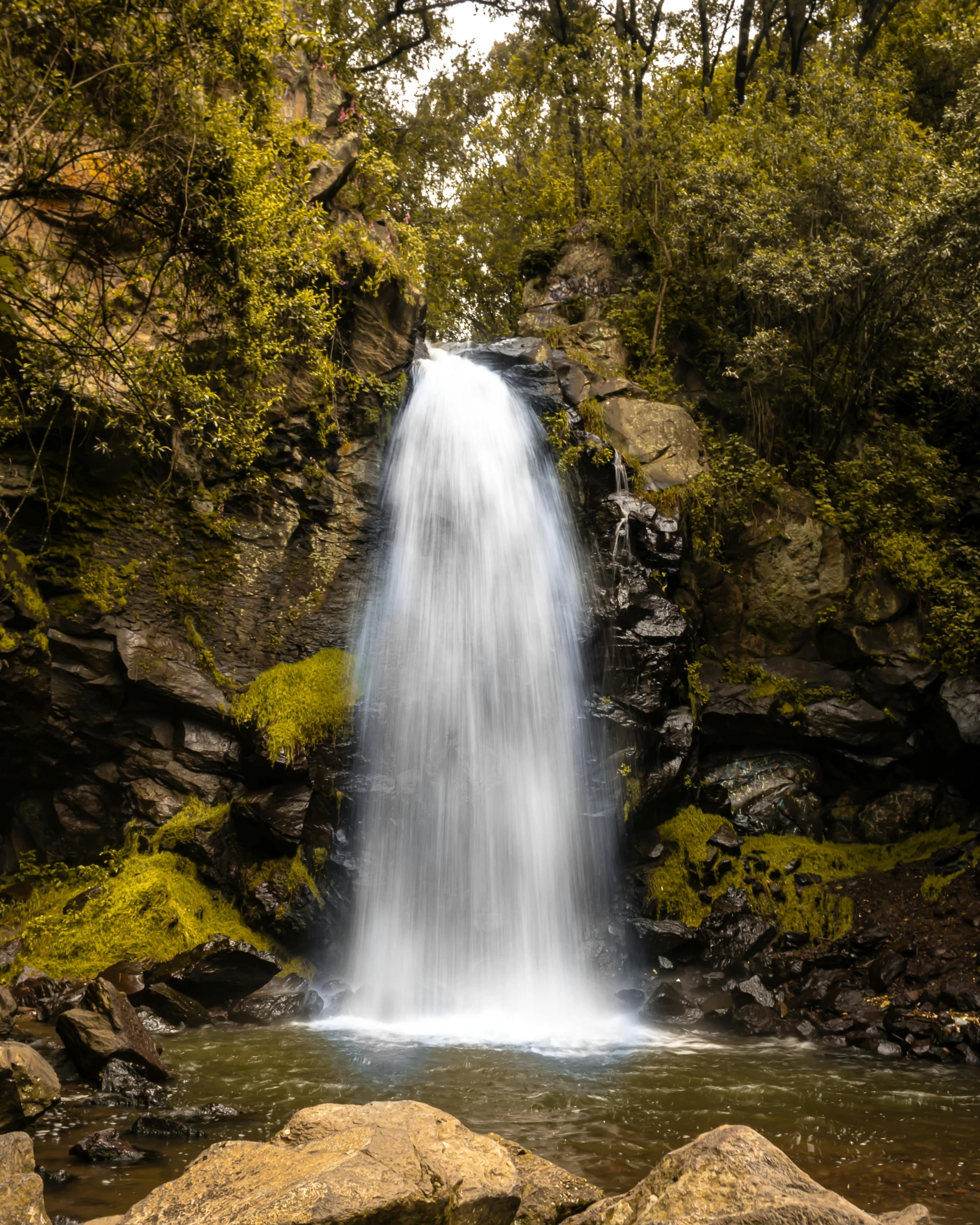 there is a waterfall in the middle of rocks