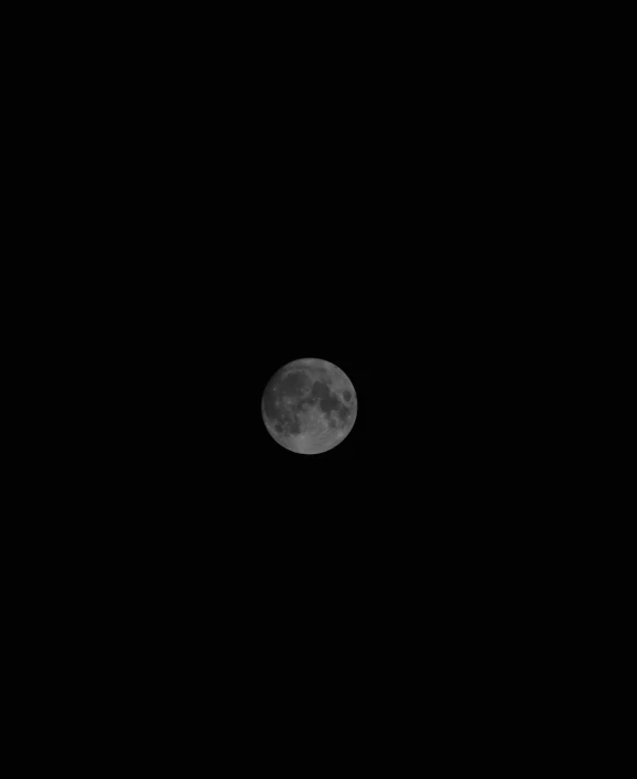 a plane flying in the dark, with the moon visible above