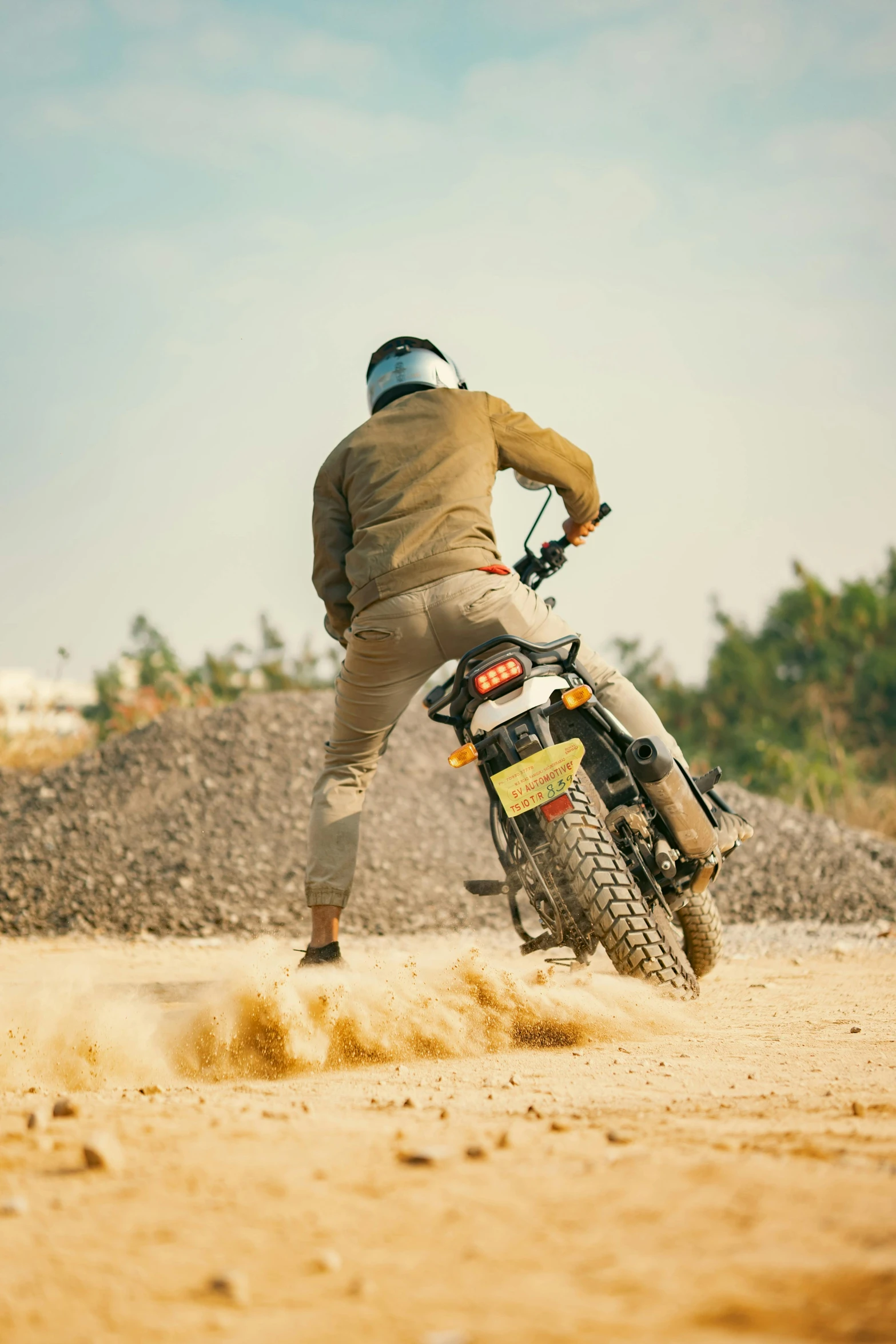 a man riding on top of a motorcycle in the dirt