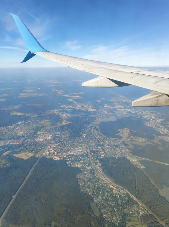 an airplane wing that is flying over a town