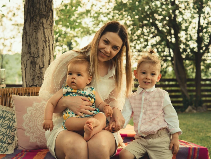 a young woman and two children on the ground