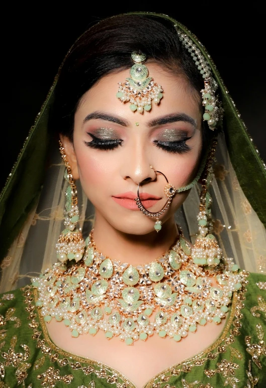 a woman wearing a green wedding outfit and a jewelry set