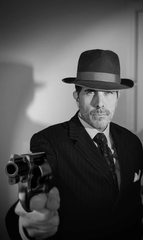 man in a hat with gun and tie