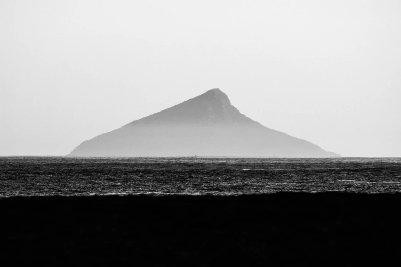 an island is shown in the middle of a foggy sea