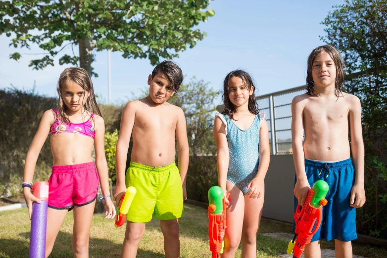 four young children with colorful shorts posing for a picture