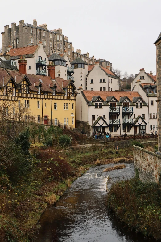 a view of the back of several buildings and a river running through them