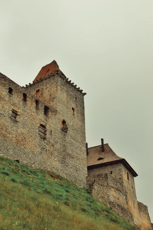 an old stone castle on a grassy hill